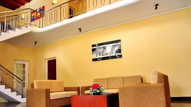 A lobby with a staircase, a reception desk, and a large abstract painting on the wall.
