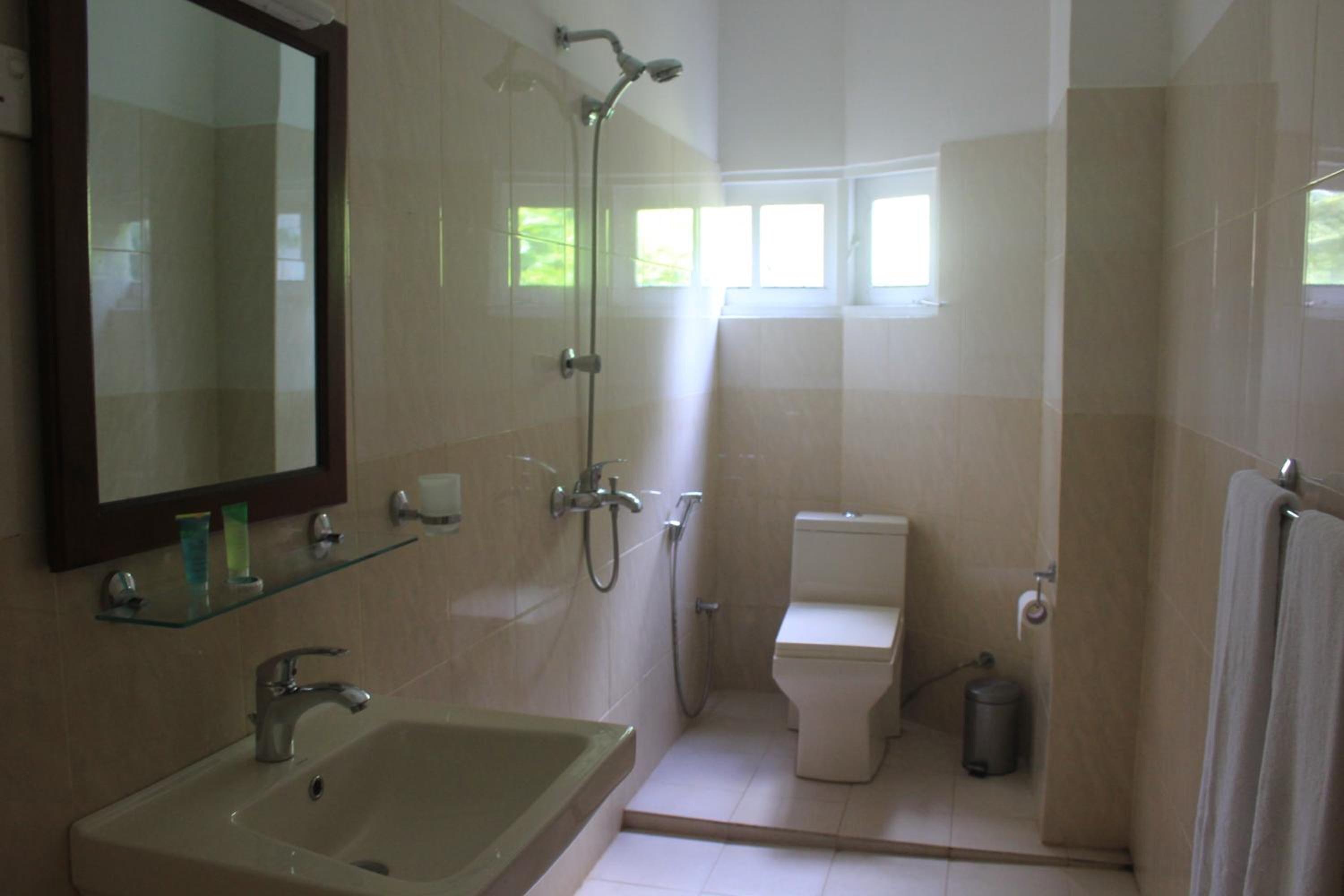Un bagno con lavandino, specchio, doccia e WC.