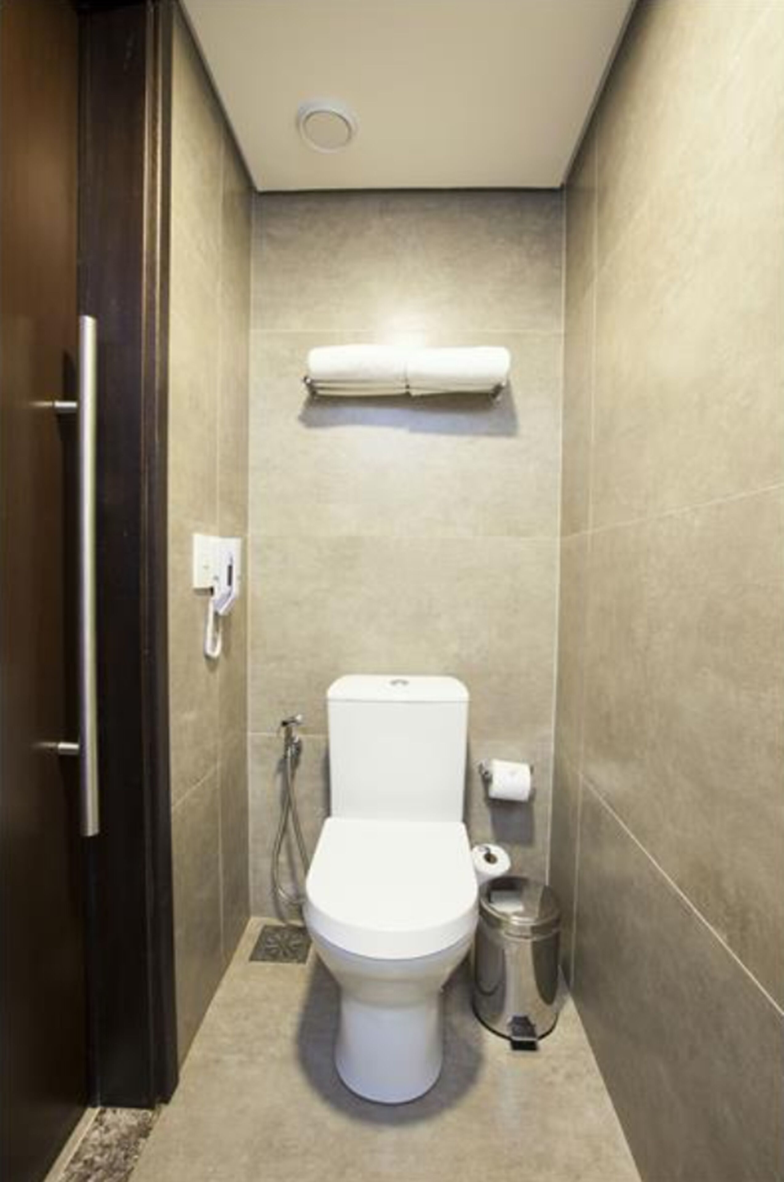 Et moderne badeværelse med toilet, bidet og skraldespand.