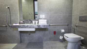 A modern bathroom with a marble countertop, a white toilet, and a shower area.