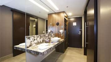 Un baño moderno con encimera de mármol, un lavabo grande y un espejo.