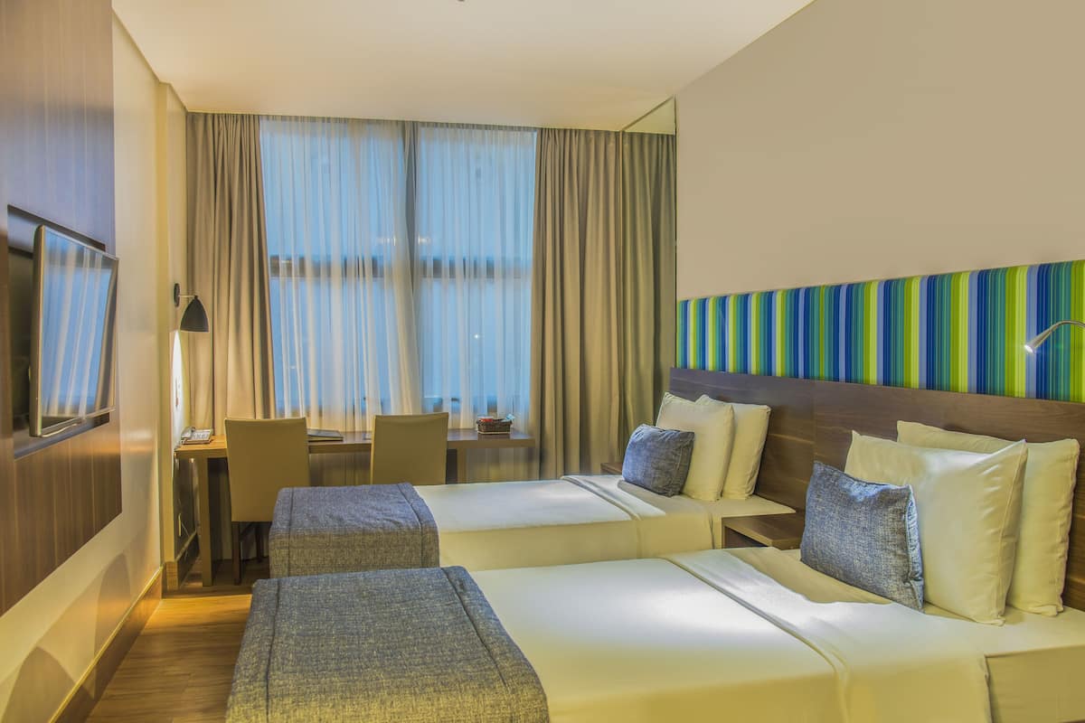 Una habitación de hotel con dos camas, un escritorio y una silla.