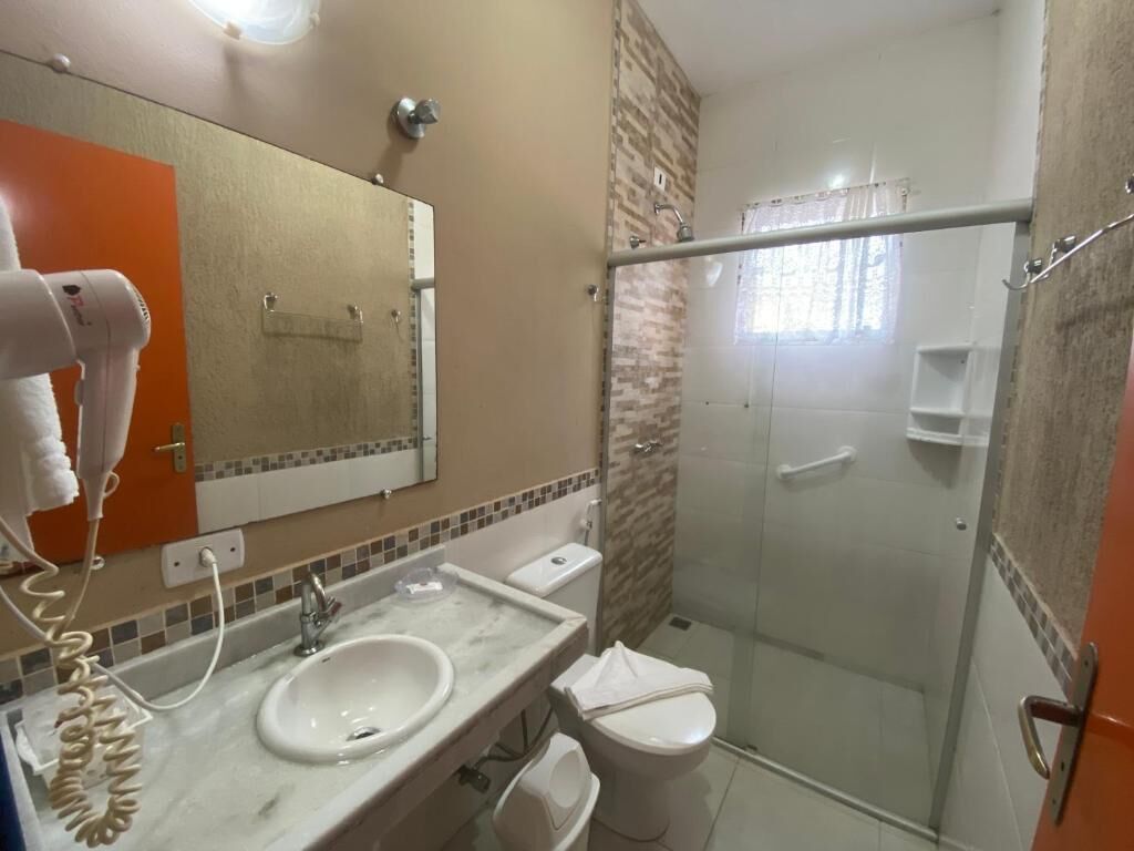 A bathroom with a sink, toilet, and shower.
