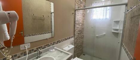 Un baño con lavamanos, inodoro y ducha.