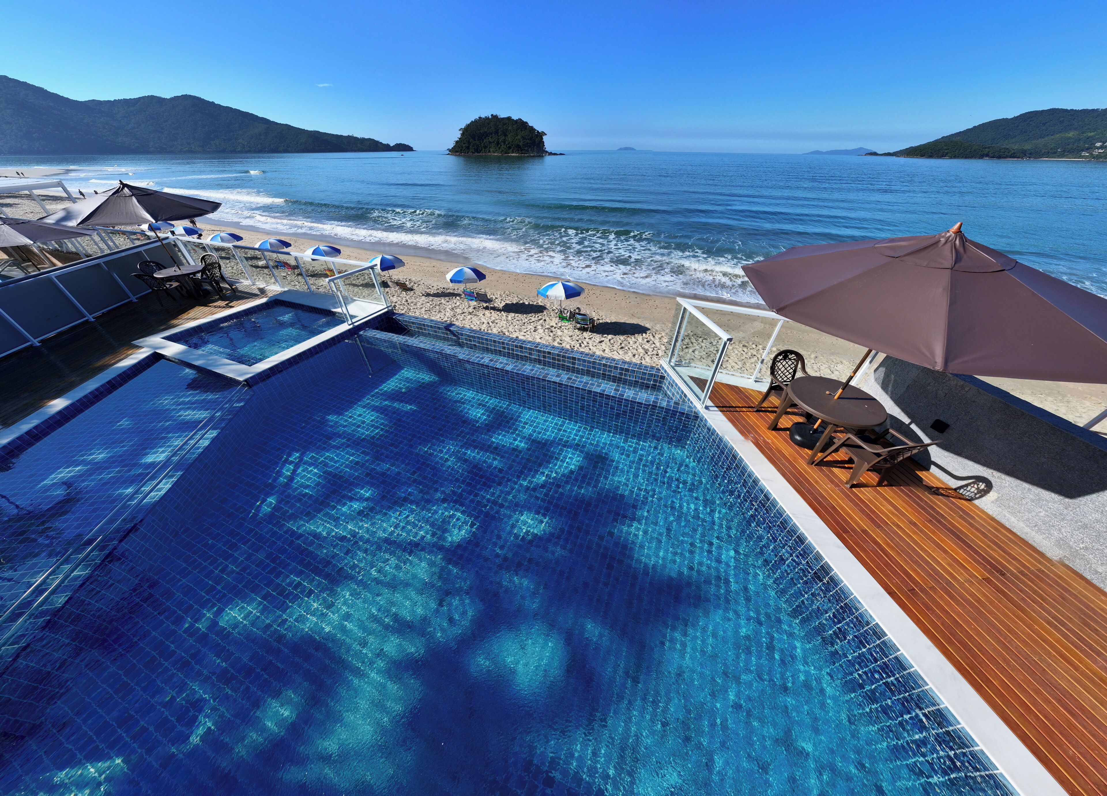 Una piscina con vistas al mar y una pequeña isla.