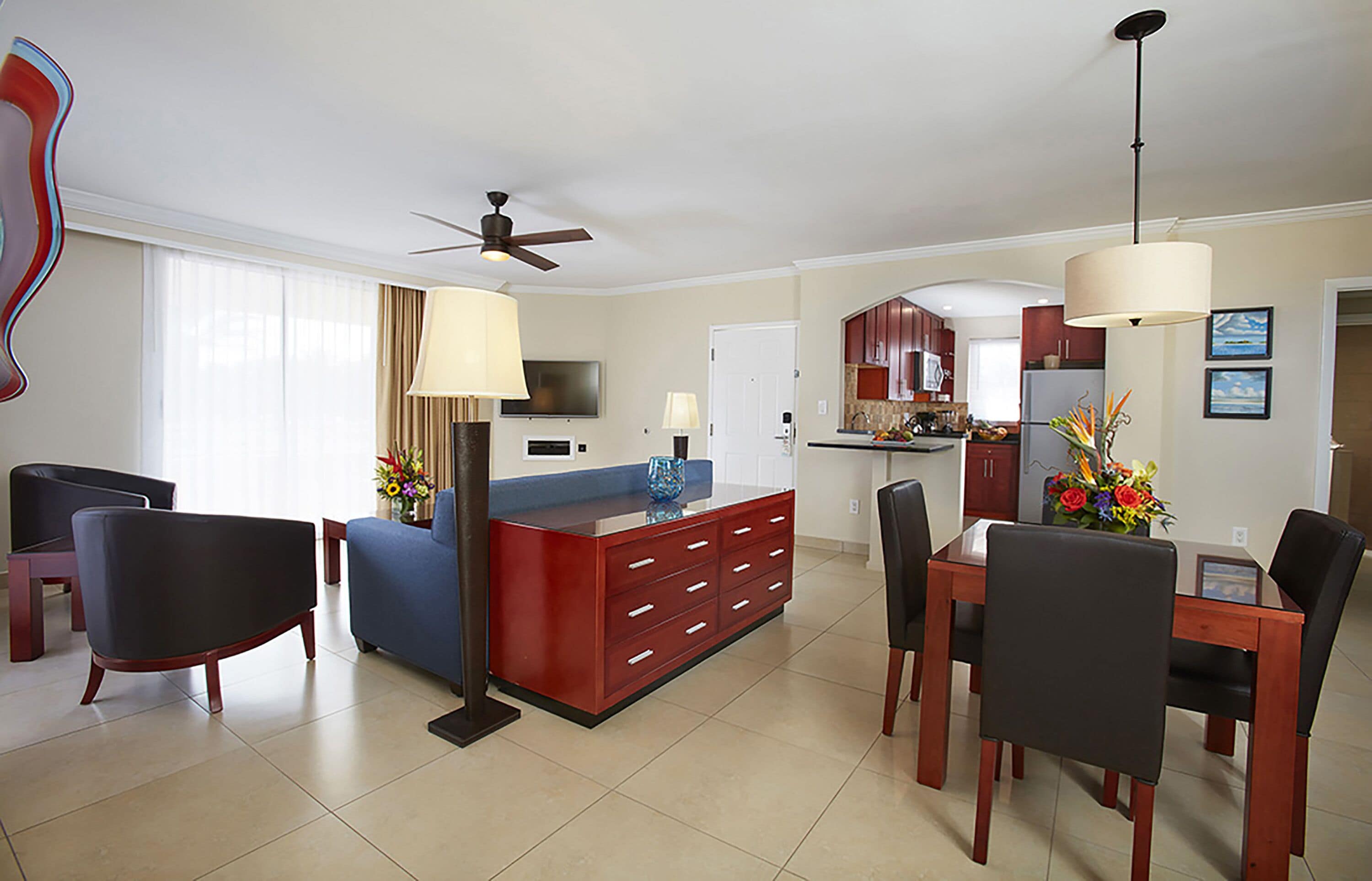 A modern living room with a sofa, a coffee table, and a dining area with chairs and a table.