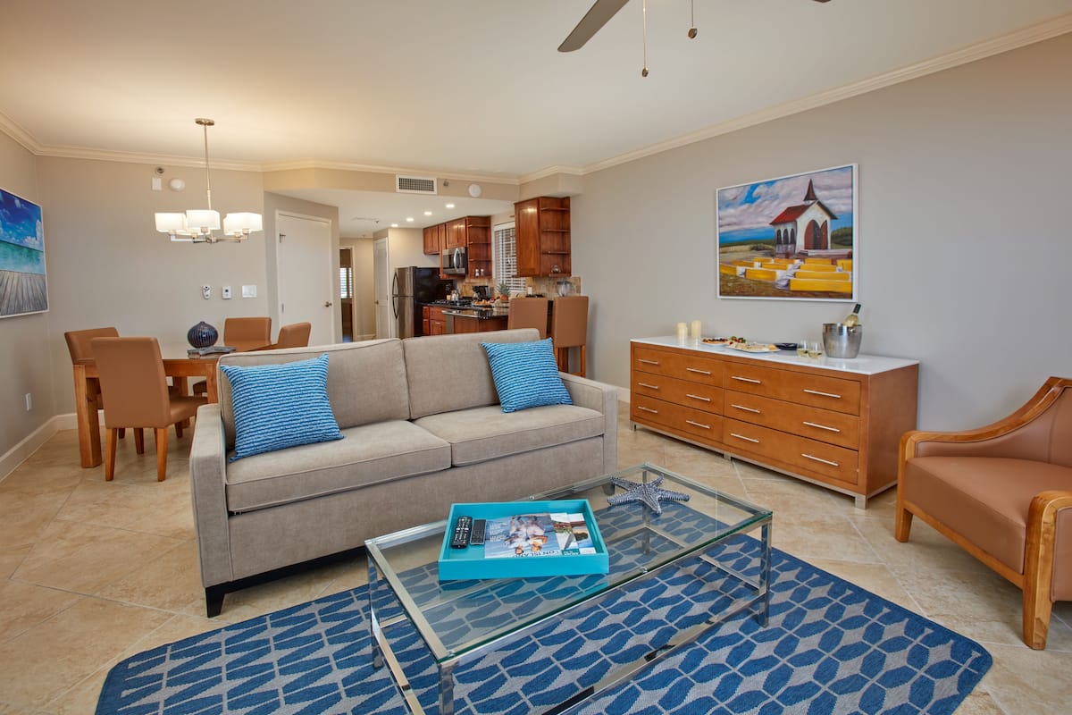 A modern living room with a sofa, coffee table, and dining area.