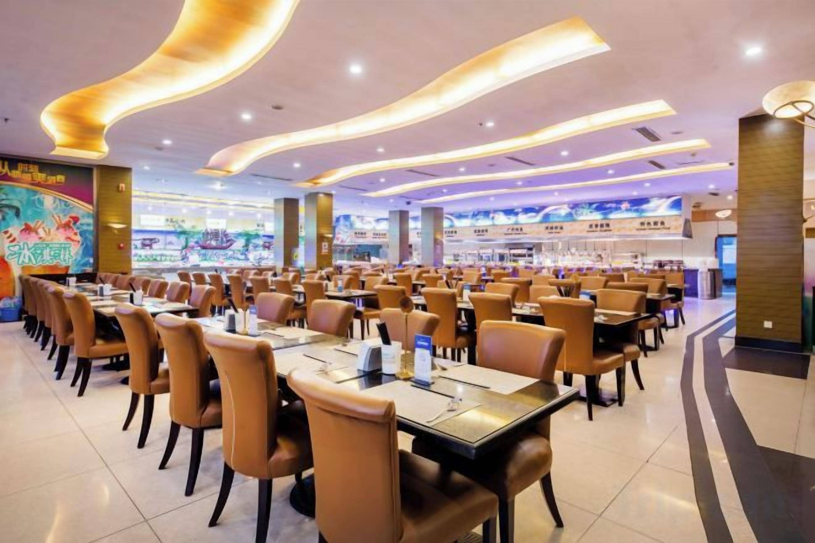 A spacious restaurant with multiple tables and chairs, a modern ceiling design, and a visible counter area.