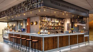 A bar area with a wooden counter, bar stools, and a variety of bottles and glasses. - Radisson Blu Metropol Hotel, Helsingborg (Helsingborg)
