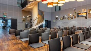 A conference room with rows of chairs, a spiral staircase, and a clock on the wall.