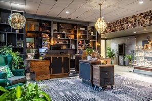 A modern hotel lobby with a central reception desk, comfortable seating, and a variety of decorative items and plants. - Radisson Blu Metropol Hotel, Helsingborg (Helsingborg)