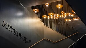 A modern staircase with a 'METROPOLIS' sign, wooden handrails, and hanging pendant lights. - Radisson Blu Metropol Hotel, Helsingborg (Helsingborg)