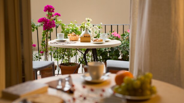 A round table with a breakfast setting, including bread, pastries, and a fruit bowl. - B&B Santa Maria del Fiore (Florence)