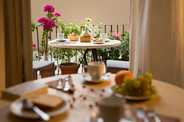 A round table with a breakfast setting, including bread, pastries, and a fruit bowl. - B&B Santa Maria del Fiore (Florence)