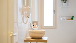 A bathroom with a large beige sink, a hairdryer, and a towel rack. - B&B Santa Maria del Fiore (Florence)