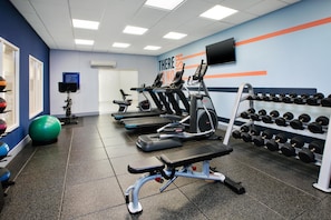 A gym with treadmills, elliptical machines, a bench press, and a rack of dumbbells. - Hampton Inn North Little Rock McCain Mall (North Little Rock)
