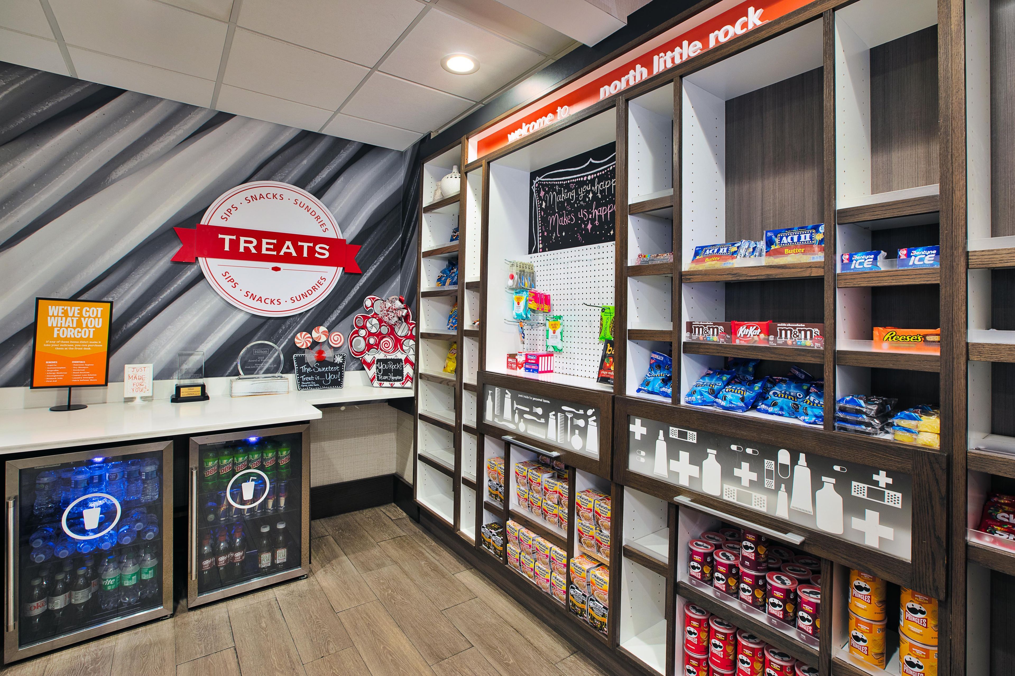 A snack and beverage section with shelves stocked with various snacks and drinks, a 'TREATS' sign, and a 'WE'VE GOT WHAT YOU FORGOT' sign.