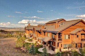A large, multi-story wooden building with a prominent roofline and stone foundation.