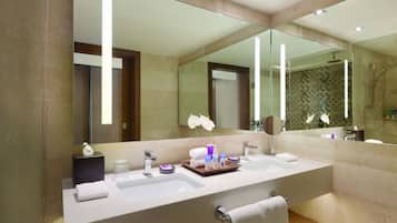 Une salle de bain moderne avec un grand miroir, deux lavabos et un espace coiffeuse.