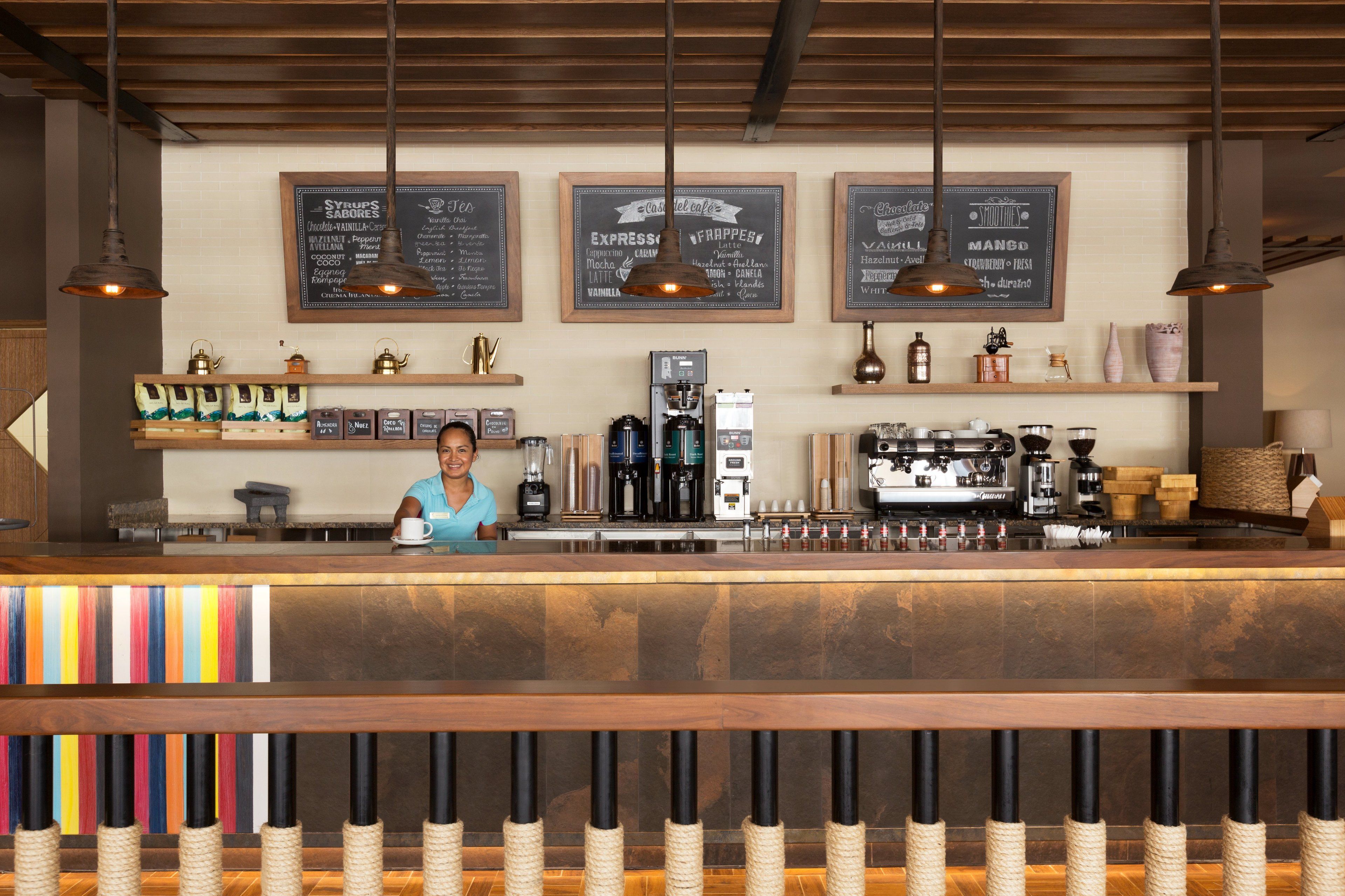 A bar area with a counter, coffee machines, and shelves with various items.