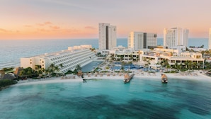 A resort with multiple high-rise buildings, a beachfront, and a pool area. - Hyatt Ziva Cancun All Inclusive (Cancun)