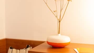 A wooden desk with a vase of dried flowers, a handbag, and a chair.