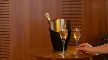 Une table en bois avec une bouteille de champagne et deux verres.