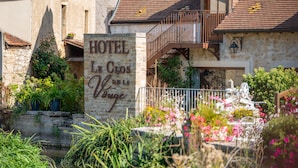 Un bâtiment en pierre sur lequel on peut lire l’inscription : « HÔTEL Le Croix de la Vigne ».