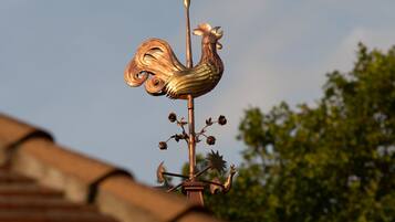 A weather vane with a rooster design on a building's roof.