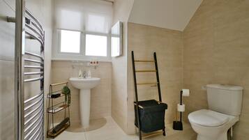 A bathroom with a toilet, sink, and towel rack.