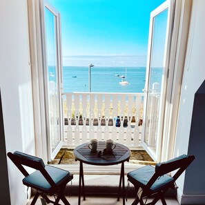 A balcony with a view of the sea, a table with two chairs, and a railing. - The Beaches Guest House (Southend-on-Sea)