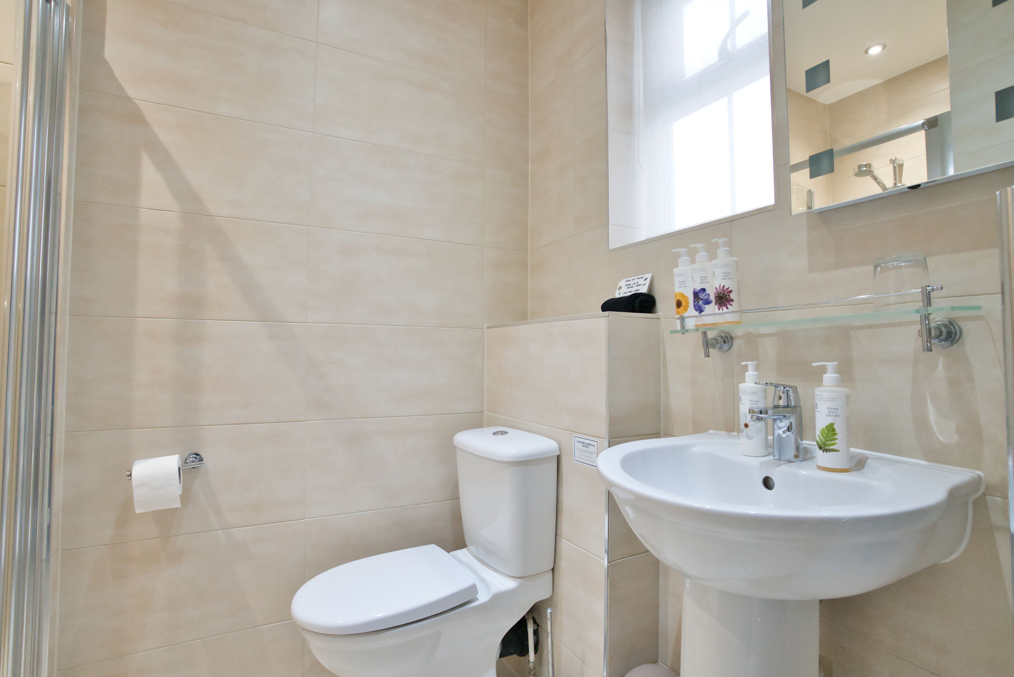 A modern bathroom with a toilet, sink, and shower.