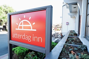 Ein Schild mit der Aufschrift 'atterdag inn' und einem Sonnensymbol, das ein Hotel kennzeichnet.
