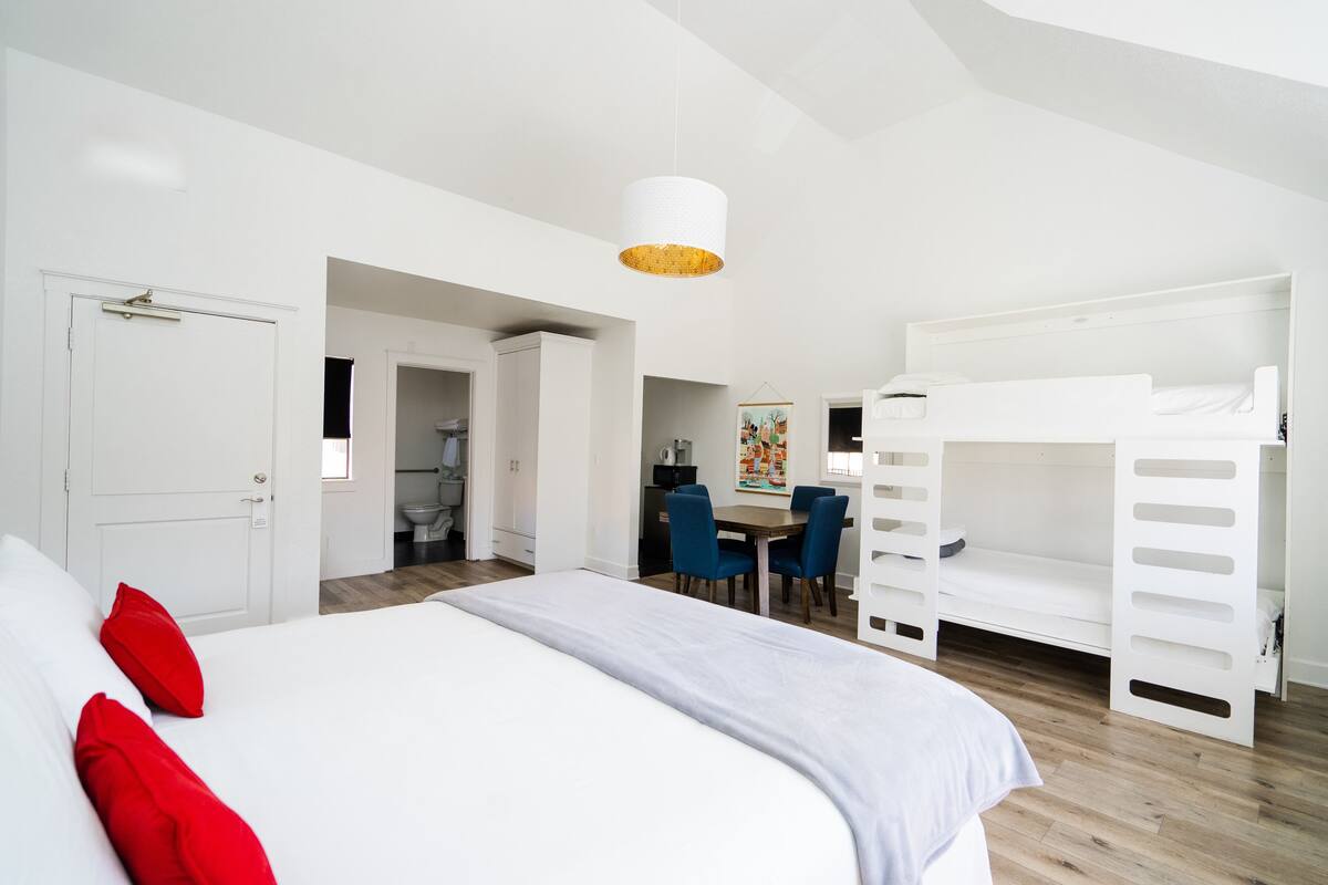 A modern bedroom with a bunk bed, a desk, and a chair.