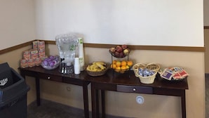 A table with a mounted deer head, a water dispenser, and various food items.
