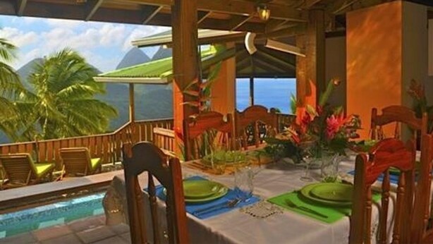 A covered outdoor dining area with a pool, wooden furniture, and tropical plants. - Piton Deck Villa (Soufrière)