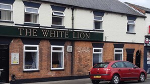 Un edificio con un cartel que dice "THE WHITE LION".