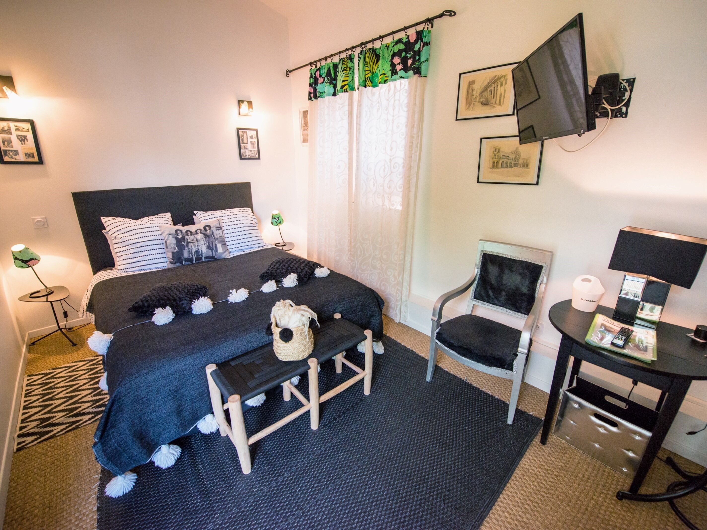 A neatly arranged bedroom with a bed, bedside tables, a chair, and a desk.