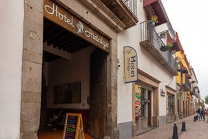 Entrada de un hotel con un letrero que dice "Hotel Hidalgo" y otro letrero que indica "Hotel Bilingue".