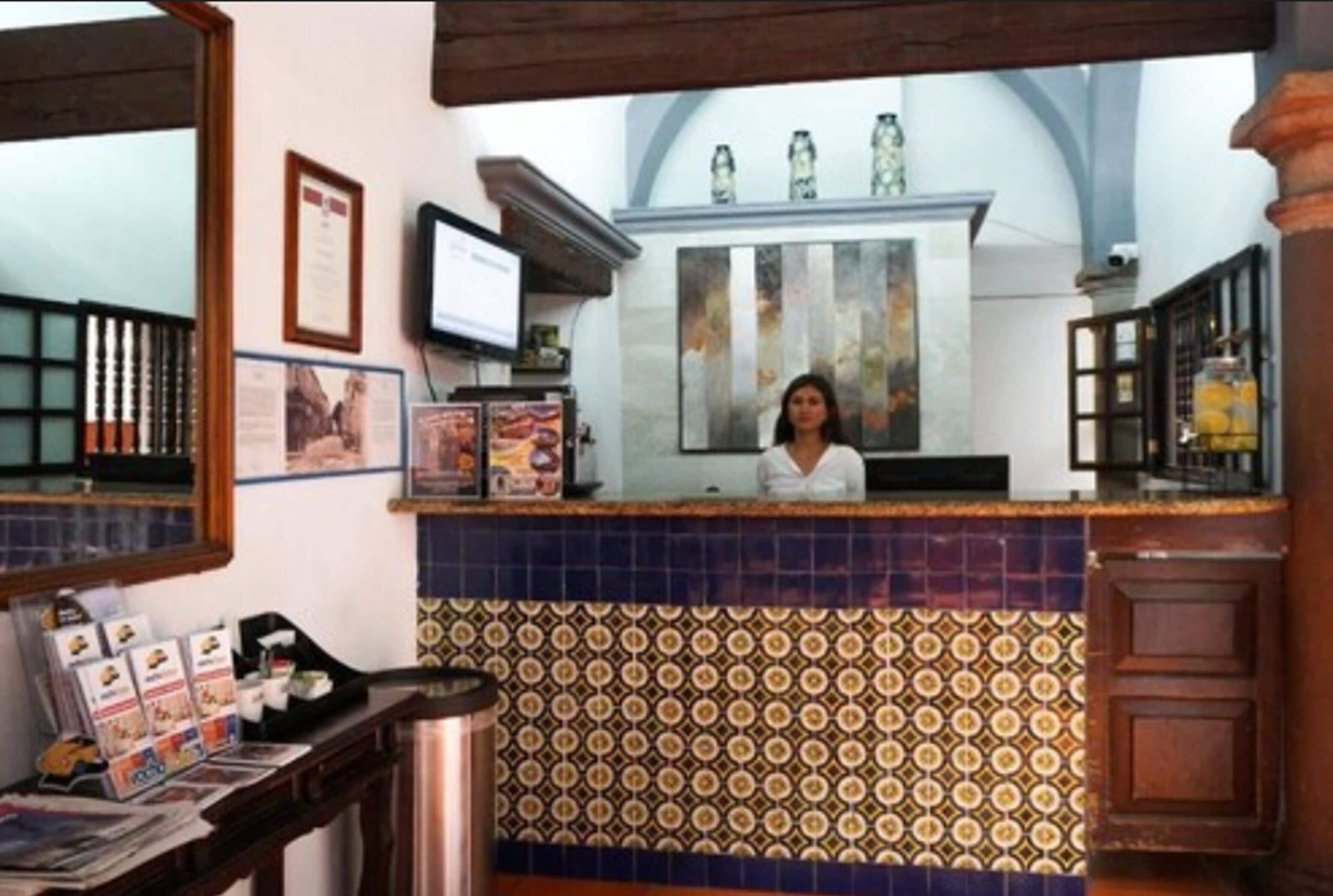 A reception area with a tiled counter, a television, framed pictures, and a window with a view of the sky.