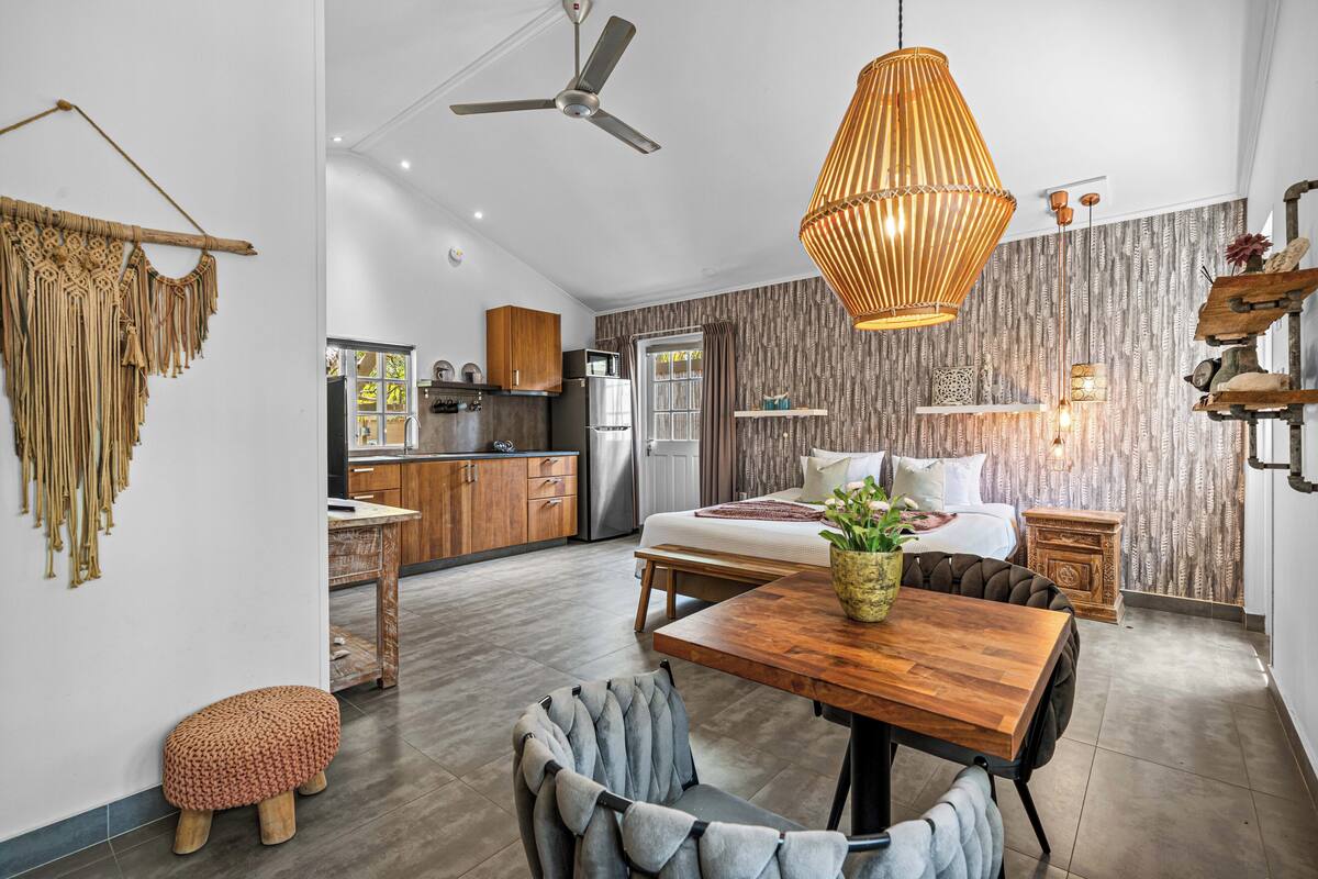 Una cocina moderna con armarios de madera, un refrigerador y un comedor con una mesa y sillas de madera.