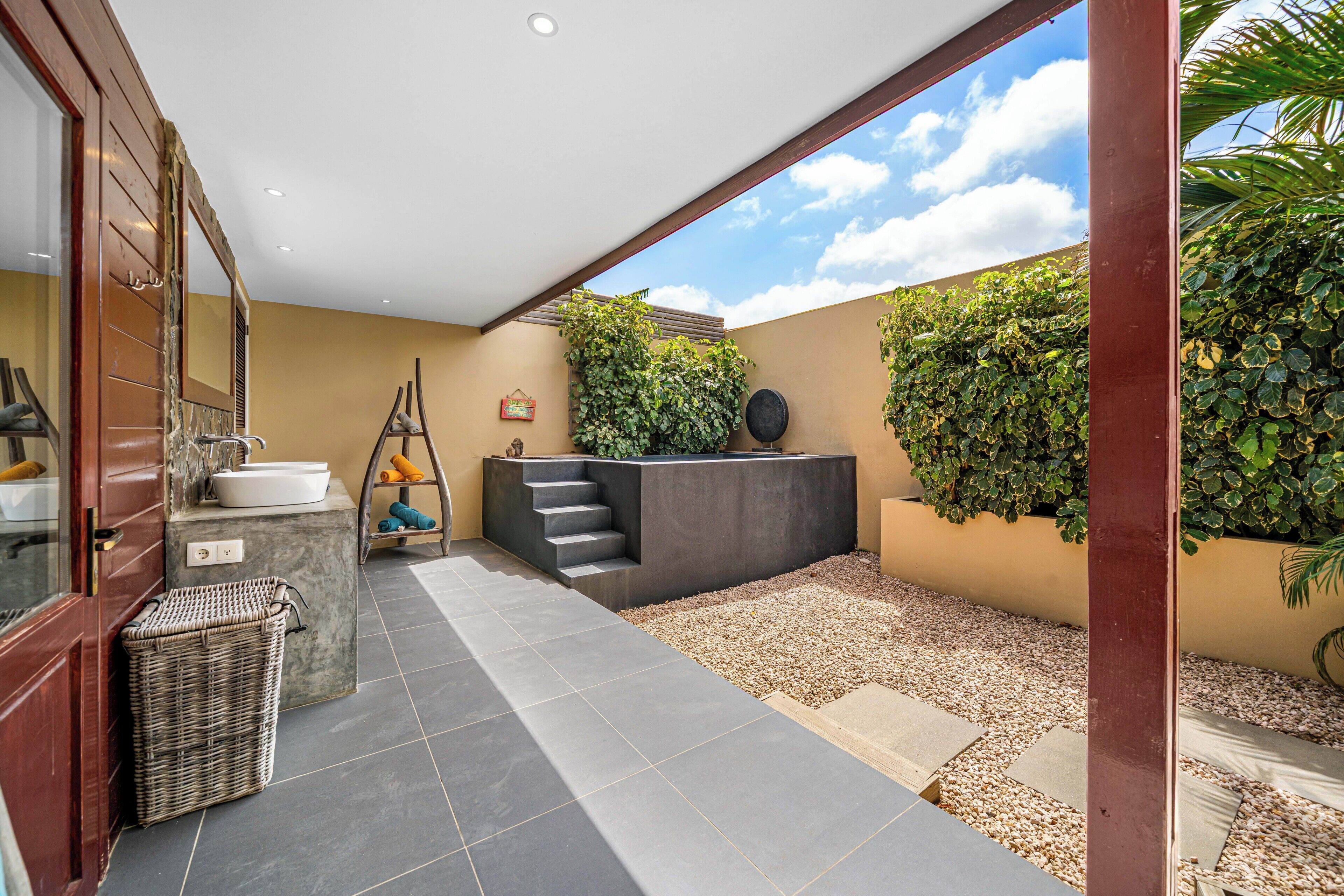 A modern bathroom with a large window, a sink, and a towel rack.