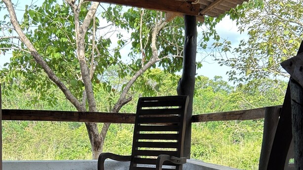 An outdoor seating area with two wooden benches under a shelter.