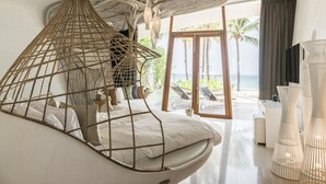 A modern bedroom with a hanging chair, a view of the beach, and a large window. - Iniala Beach House (Takua Thung)