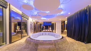 Relax in a stylish seating area surrounded by a textured carpet and contemporary ceiling design.