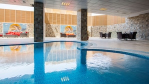 A swimming pool with tiled walls and a mural, surrounded by lounge chairs and tables. - Radisson Blu Hotel, Jeddah Plaza (Jeddah)