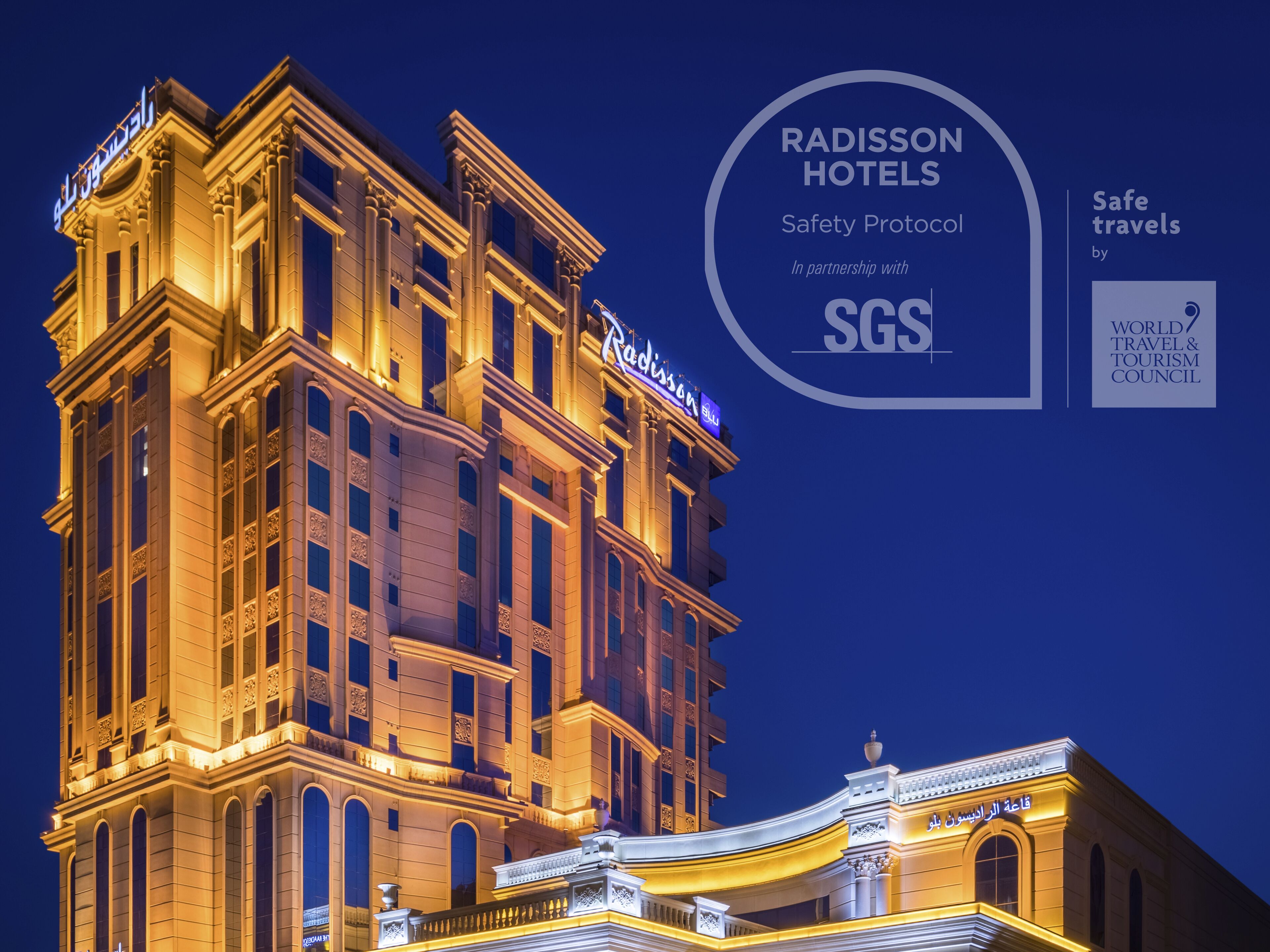 A grand hotel with classical architecture, illuminated at night.