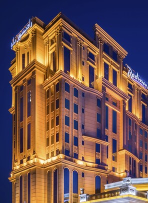 A multi-story hotel with a classic architectural design, featuring arched windows and decorative moldings.