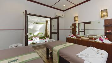 Two beds with matching headboards, a large mirror, and a window offering a view of the outdoors.