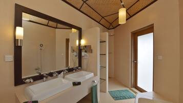 Une salle de bain moderne avec deux lavabos, un grand miroir et un espace douche.